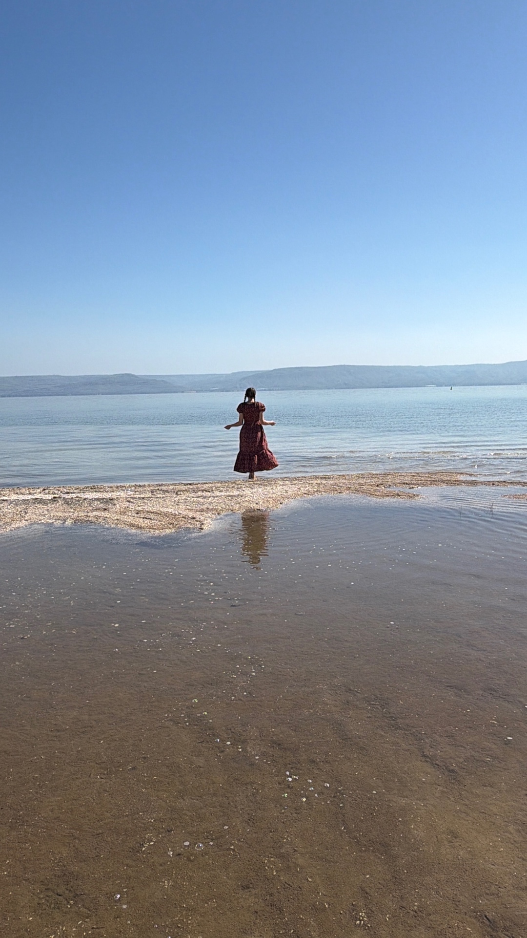 Woman in red dress walking into sacred waters